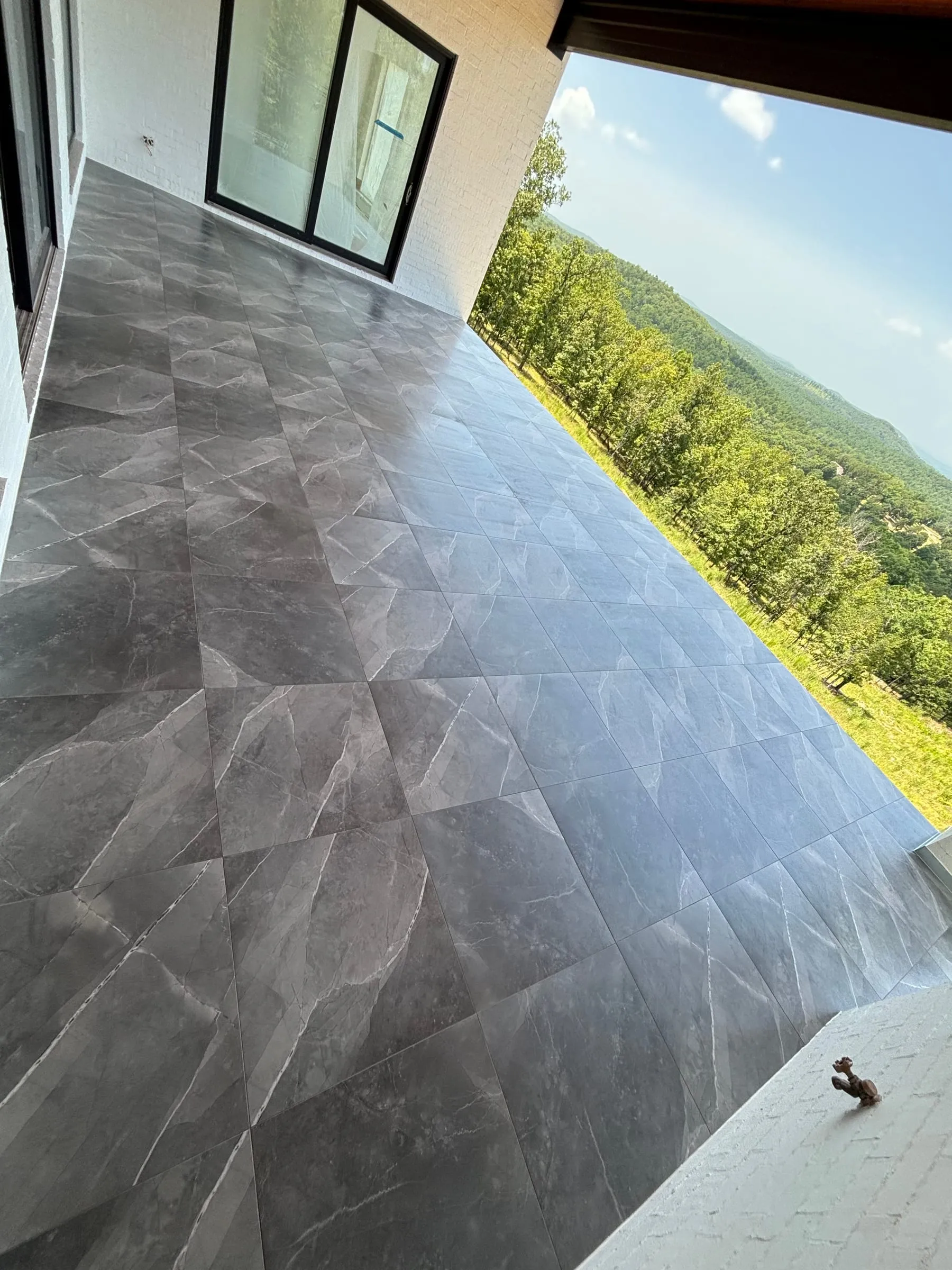 Covered deck floored in large gray marble-look porcelain