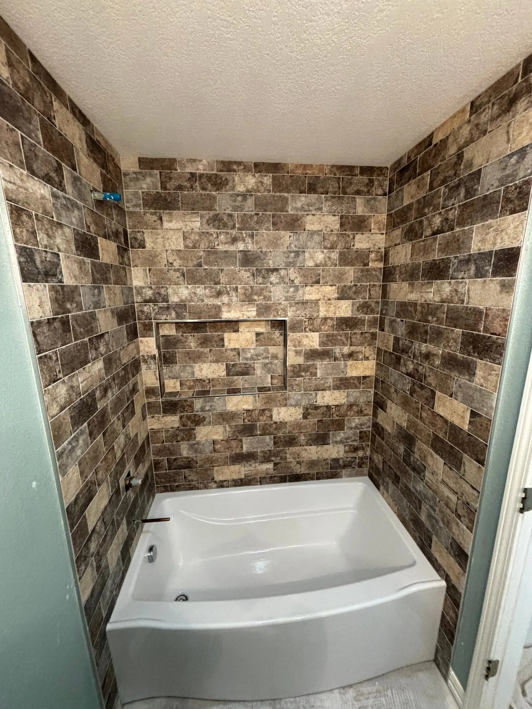 Tub surround in brick-look tile with a recessed niche