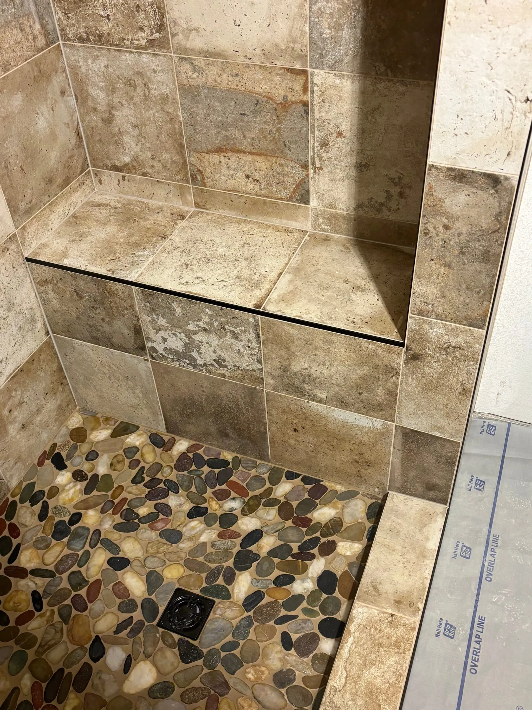Tiled bench and river-rock pebble shower floor