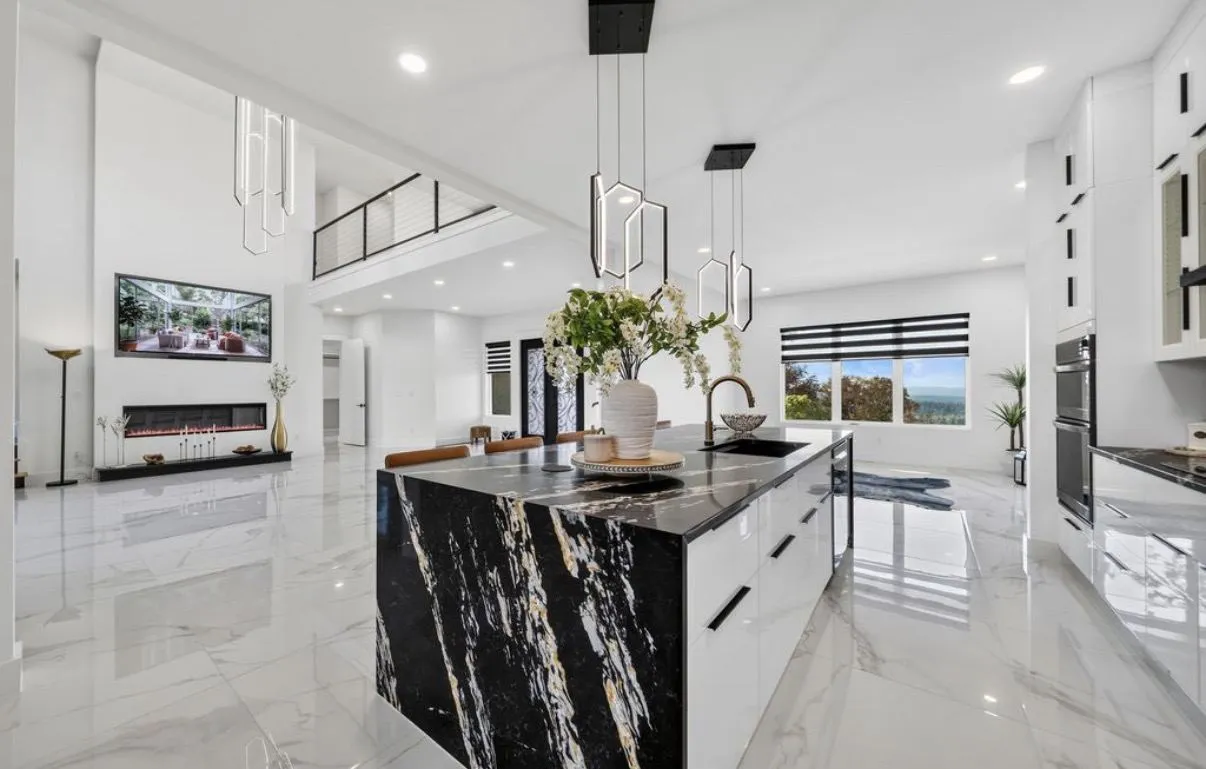 Open kitchen with marble-look porcelain floor and a black marble waterfall island