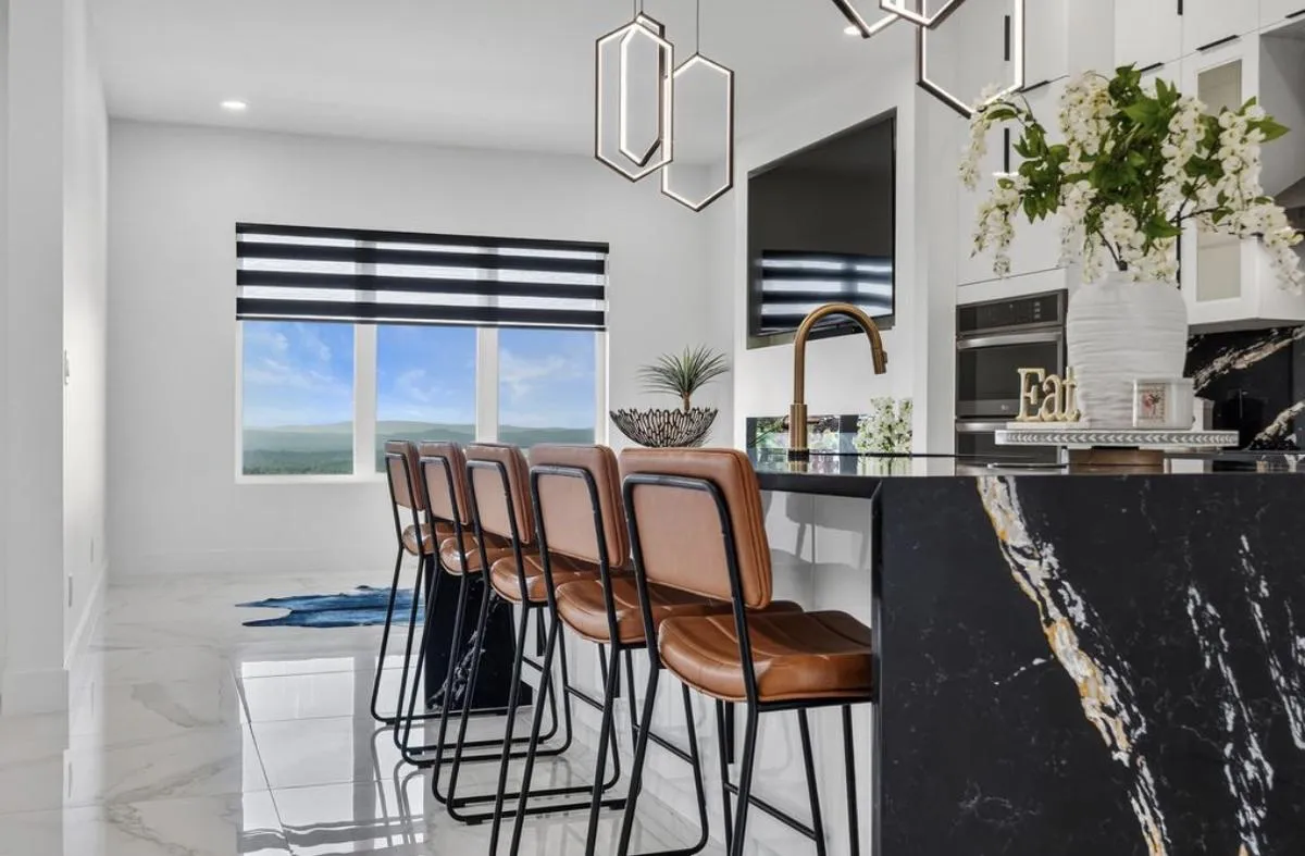 Kitchen island with a black marble waterfall edge and bar stools