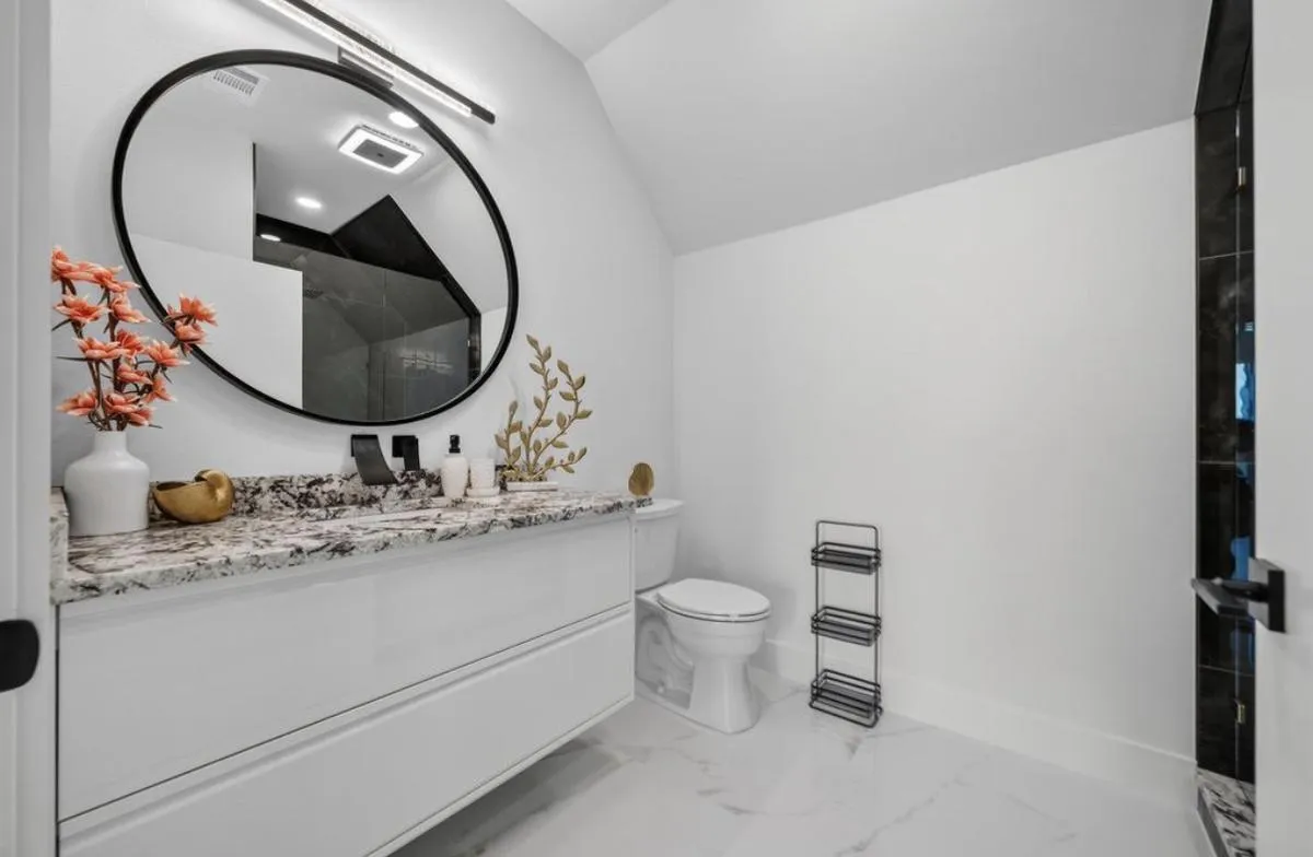 Powder room with a floating vanity and white marble-look floor tile