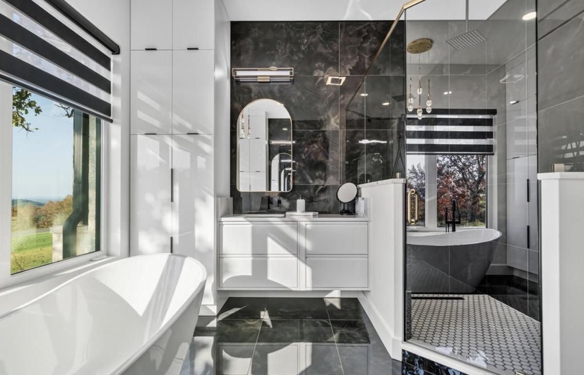 Primary bath with a glass-enclosed walk-in shower in black marble-look tile